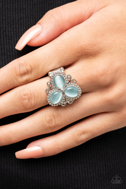 Bewitched Blossoms Blue Ring - Paparazzi Accessories  Three oval blue cat's eye stones are encased in studded silver fittings featuring filigree accents, blooming into a magical floral centerpiece atop the finger. Features a stretchy band for a flexible fit.  Sold as one individual ring.