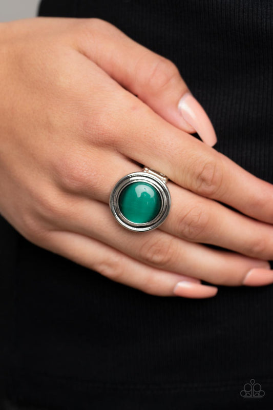 Laguna Luminosity Green Ring - Paparazzi Accessories  A green cat's eye stone is encircled in rippling silver frames, pooling into an ethereal pop of color atop the finger. Features a stretchy band for a flexible fit.  Sold as one individual ring.