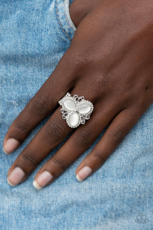 Bewitched Blossoms White Ring - Paparazzi Accessories  Three oval white cat's eye stones are encased in studded silver fittings featuring filigree accents, blooming into a magical floral centerpiece atop the finger. Features a stretchy band for a flexible fit.  Sold as one individual ring.