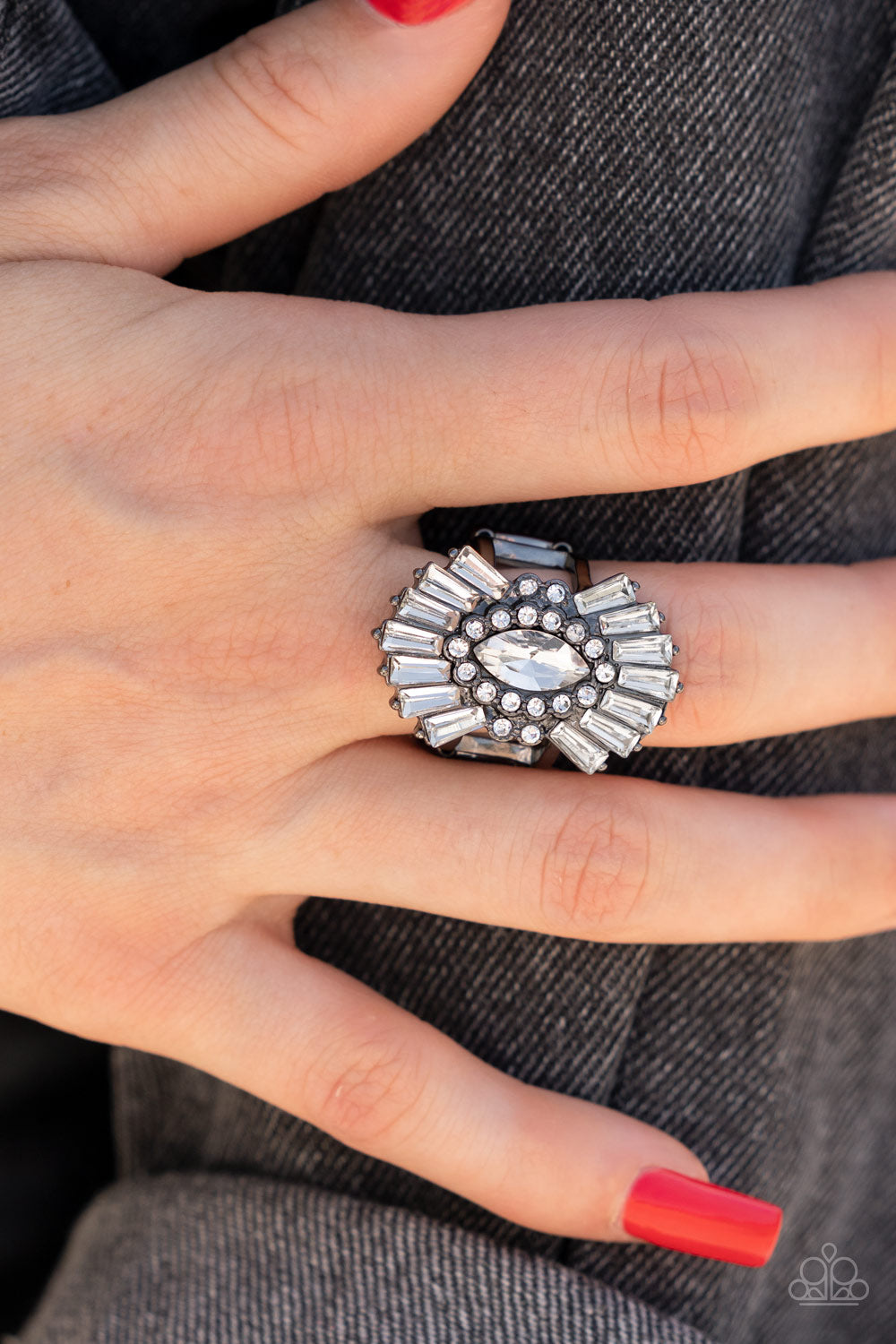 Daringly Deco Black Ring - Paparazzi Accessories   A white, marquise-cut rhinestone is bordered in glassy white rhinestones atop fans of trapezoidal-cut white rhinestones, resulting in an edgy sparkle that explodes atop the finger. Features a stretchy band for a flexible fit.  Sold as one individual ring.