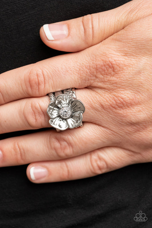 Prismatically Petunia White Ring - Paparazzi Accessories  Textured silver petals gently gather around a sparkling white rhinestone center, blooming into a dazzling floral centerpiece atop the finger. Features a stretchy band for a flexible fit.  Sold as one individual ring.
