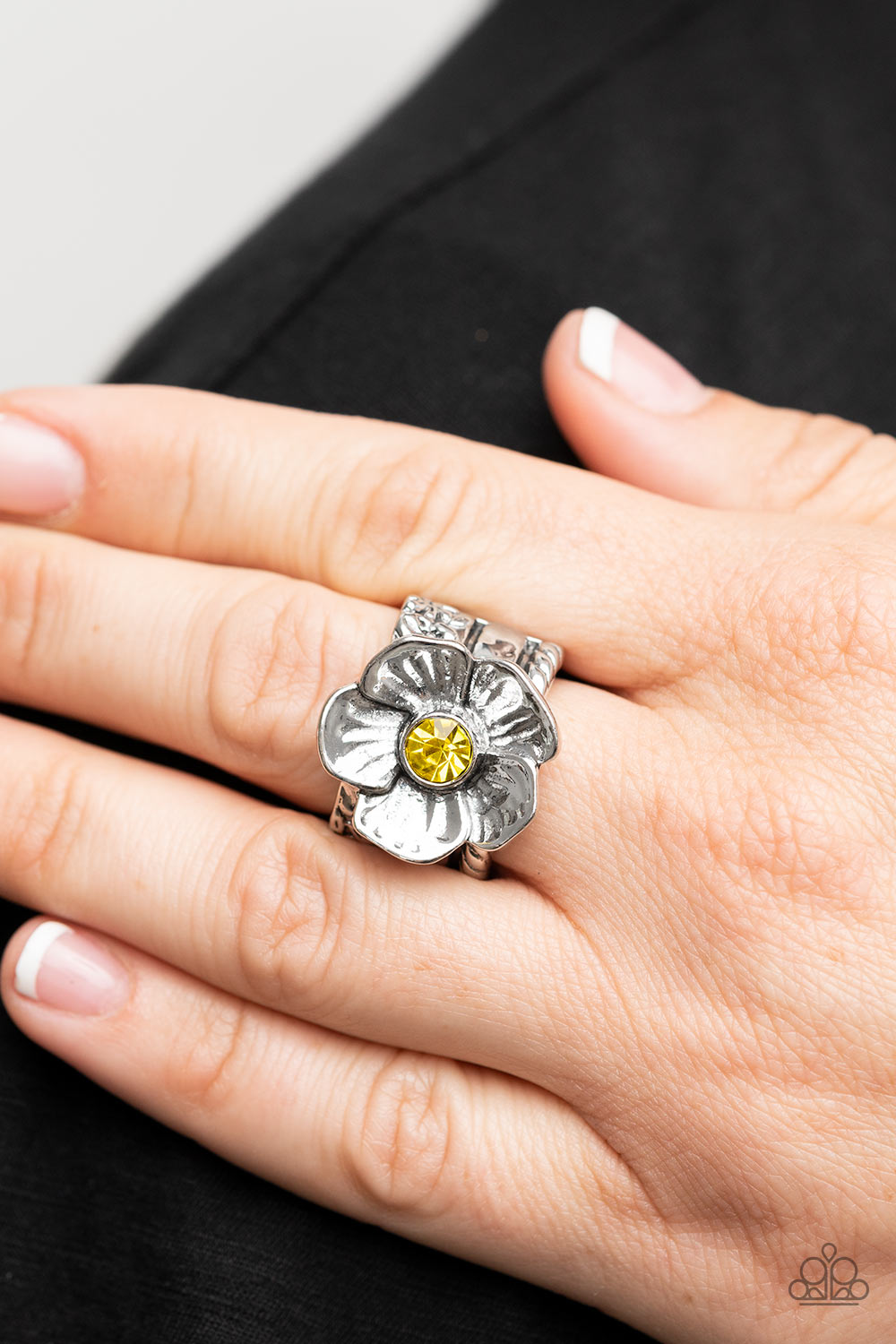 Prismatically Petunia Yellow Ring - Paparazzi Accessories  Textured silver petals gently gather around a sparkling yellow rhinestone center, blooming into a dazzling floral centerpiece atop the finger. Features a stretchy band for a flexible fit.  Sold as one individual ring.