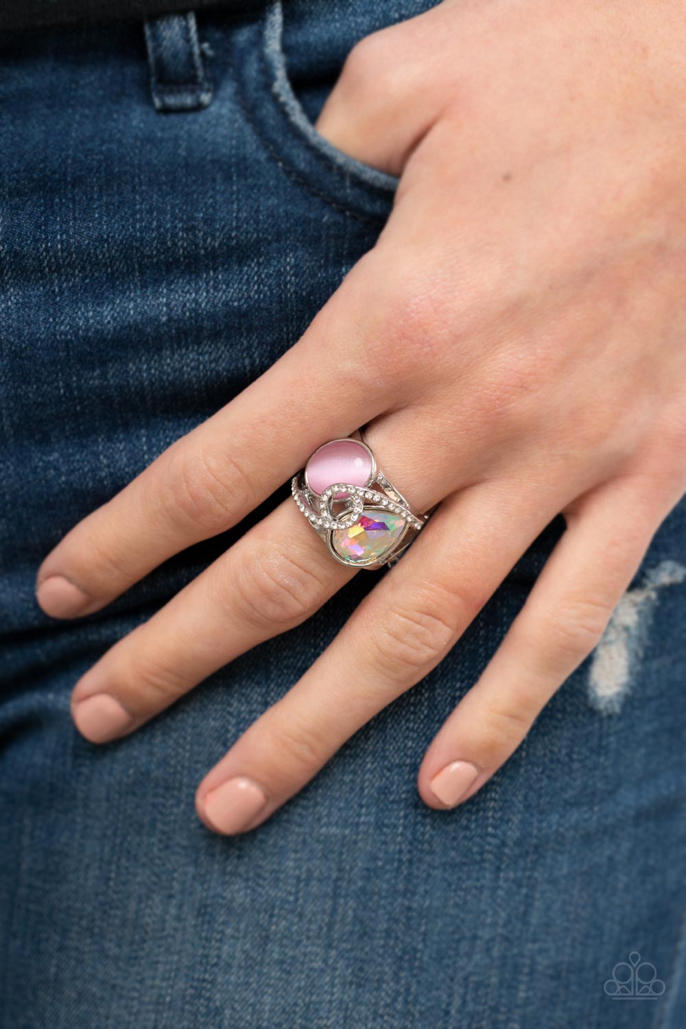 SELFIE-Indulgence Pink Ring - Paparazzi Accessories  A white rhinestone dotted silver ribbon loops and slants over a tilted pink cat's eye stone and iridescent teardrop gem, culminating into a stellar centerpiece. Features a stretchy band for a flexible fit.  Sold as one individual ring.