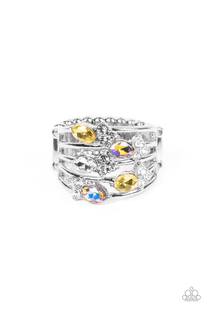 Ethereal Escapade Yellow Ring - Paparazzi Accessories  Infused with clusters of dainty white rhinestones, a glitzy collection of yellow, iridescent, and white oval rhinestones are sprinkled across layers of silver bands, creating an ethereal sparkle across the finger. Features a dainty stretchy band for a flexible fit.  Featured inside The Preview at GLOW!  Sold as one individual ring.