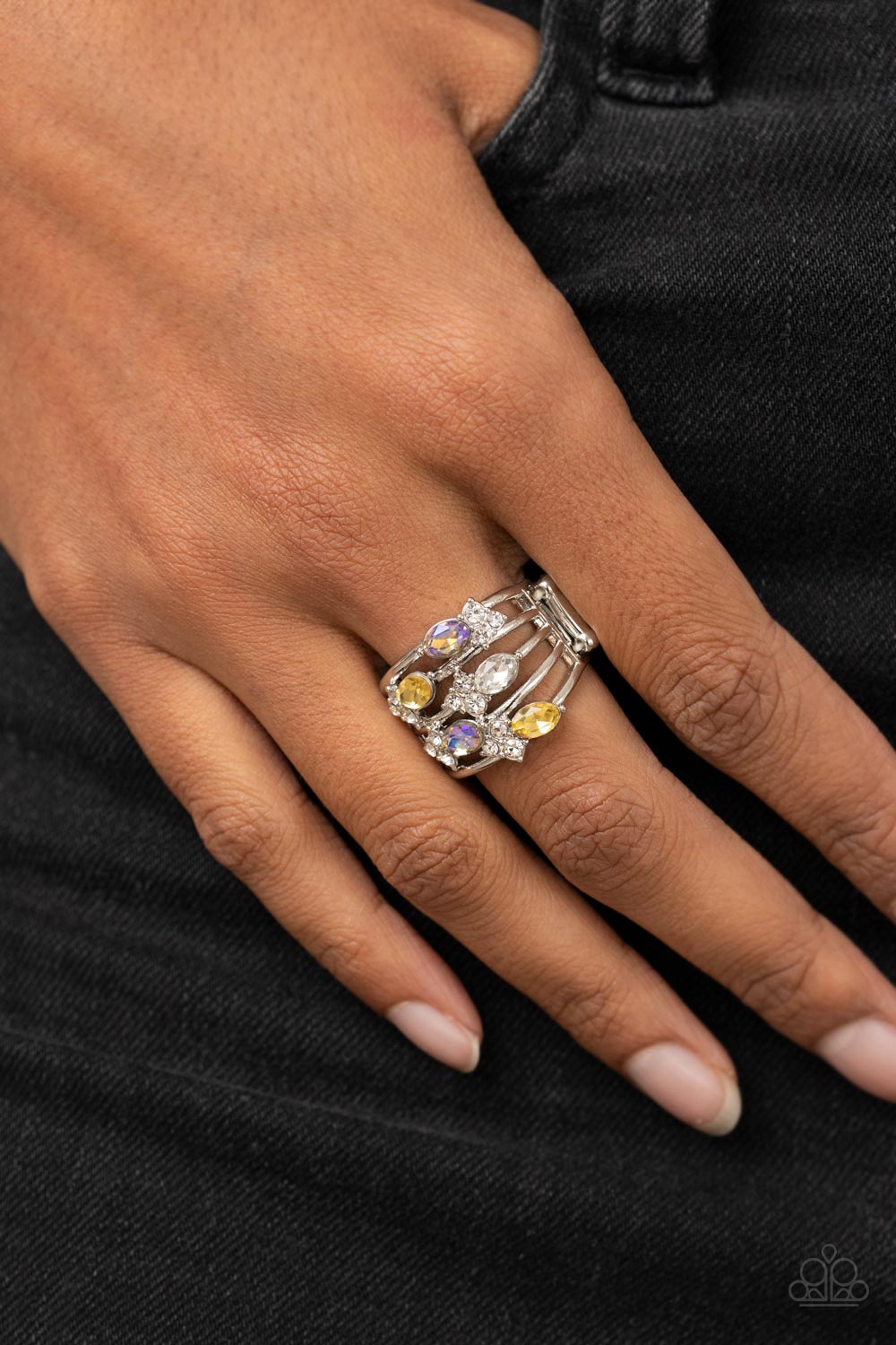 Ethereal Escapade Yellow Ring - Paparazzi Accessories  Infused with clusters of dainty white rhinestones, a glitzy collection of yellow, iridescent, and white oval rhinestones are sprinkled across layers of silver bands, creating an ethereal sparkle across the finger. Features a dainty stretchy band for a flexible fit.  Featured inside The Preview at GLOW!  Sold as one individual ring.
