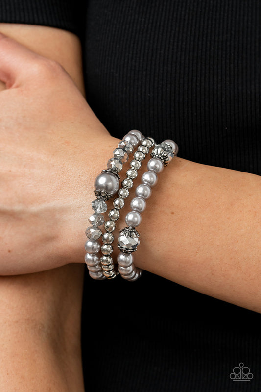 Positively Polished Silver Bracelet - Paparazzi Accessories  Stretchy silver pearl and silver beaded bracelets are adorned with ornate silver accents and glassy hematite flecked crystal-like beads, creating polished layers around the wrist.  Sold as one set of three bracelets.