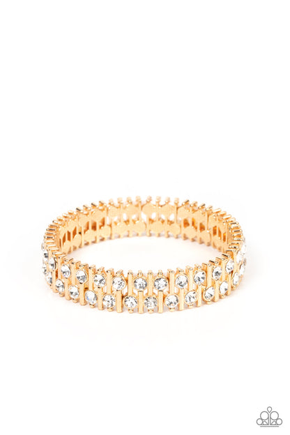 Generational Glimmer Gold Bracelet - Paparazzi Accessories  Attached to gold bars, a staggered display of solitaire white rhinestones alternates along a stretchy band around the wrist for an unexpected pop of shimmer around the wrist.  Sold as one individual bracelet.