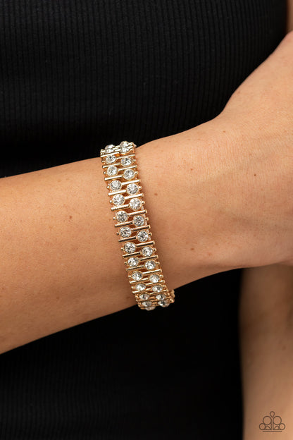 Generational Glimmer Gold Bracelet - Paparazzi Accessories  Attached to gold bars, a staggered display of solitaire white rhinestones alternates along a stretchy band around the wrist for an unexpected pop of shimmer around the wrist.  Sold as one individual bracelet.