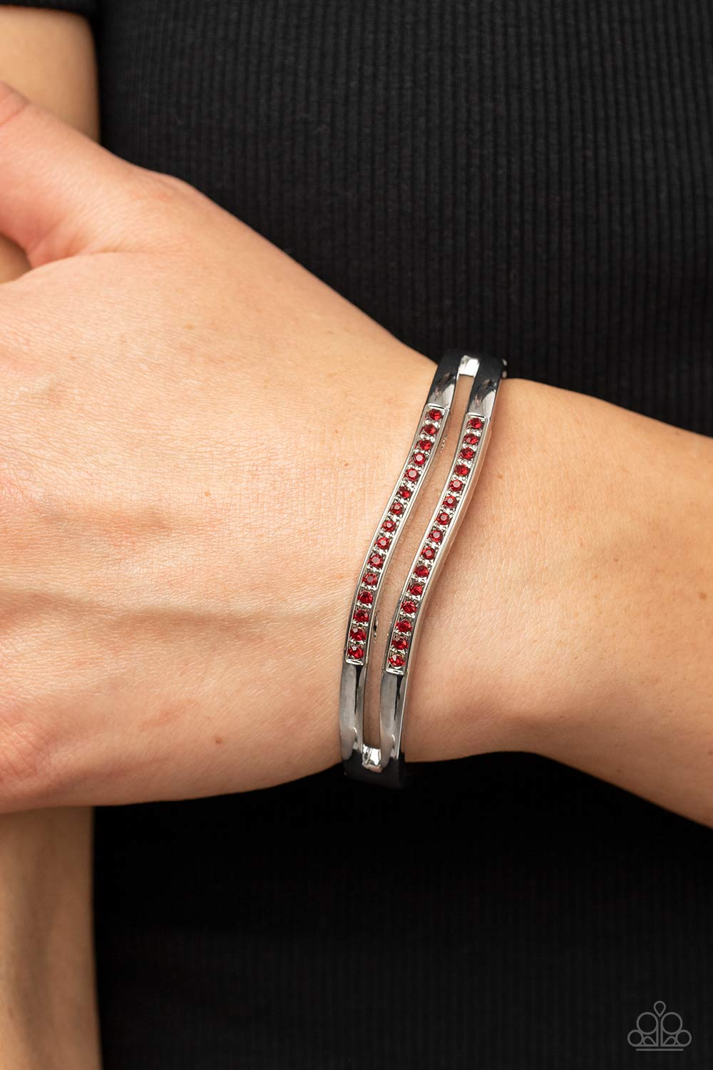 Gen Z Glamour Red Bracelet - Paparazzi Accessories  Wavy rows of silver hinge into an airy bangle-like bracelet around the wrist. Fiery red rhinestones are sprinkled across the front of the trendy centerpiece, adding a spritz of glitz to the versatile design. Features a hinged closure.  Sold as one individual bracelet.