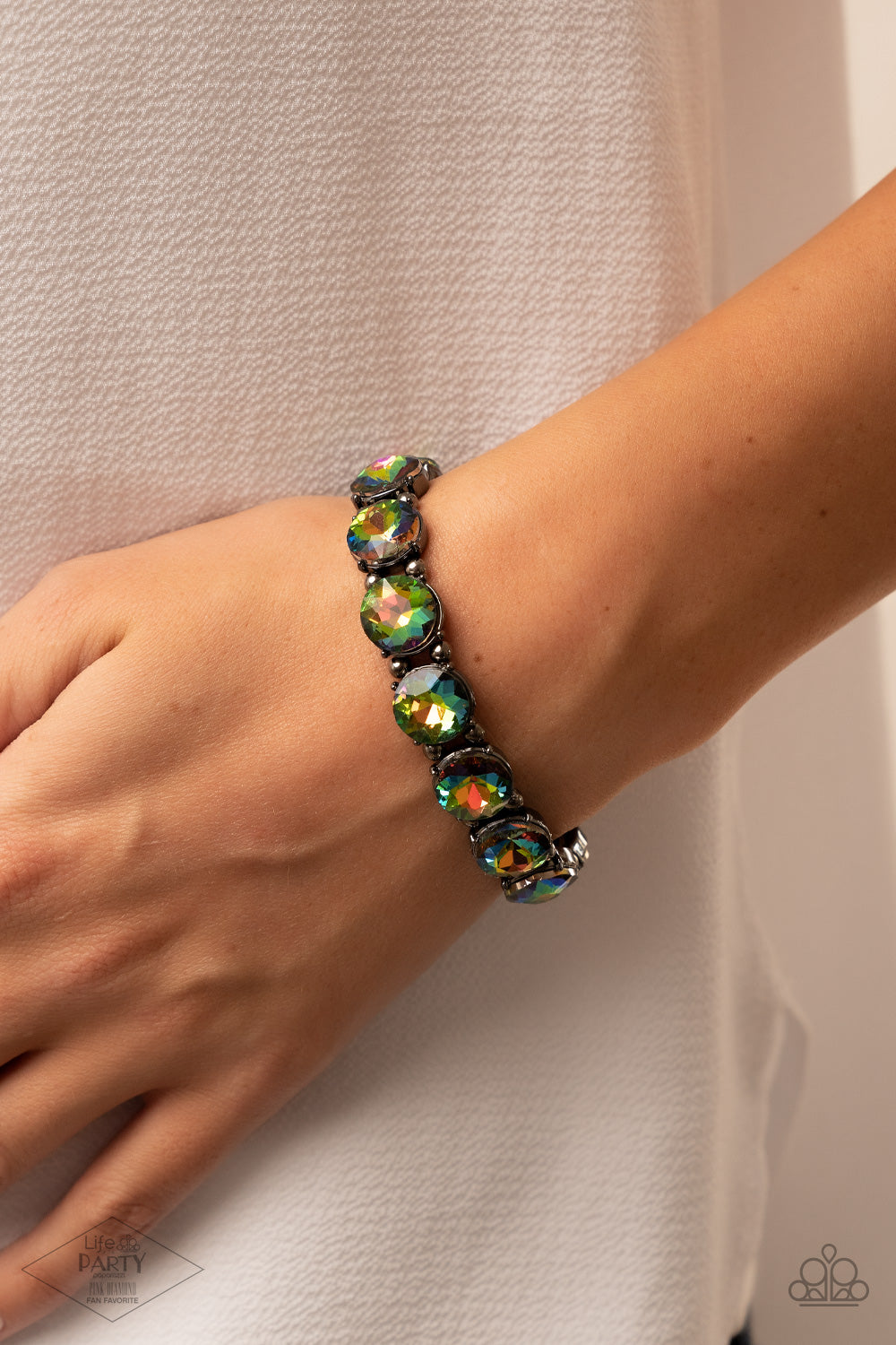 Glitzy Glamorous Multi Bracelet - Paparazzi Accessories  A row of exaggerated oil spill rhinestones is threaded along stretchy bands and wraps boldly around the wrist. Dainty gunmetal beads separate each rhinestone, adding a metallic grit to the piece.  Sold as one individual bracelet. This Fan Favorite is back in the spotlight at the request of our 2021 Life of the Party member with Pink Diamond Access, Taylerlee and Vicki B.