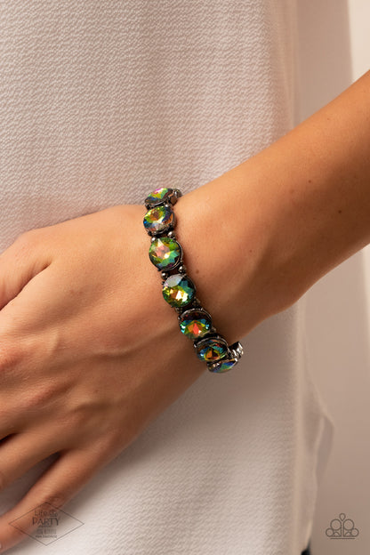 Glitzy Glamorous Multi Bracelet - Paparazzi Accessories  A row of exaggerated oil spill rhinestones is threaded along stretchy bands and wraps boldly around the wrist. Dainty gunmetal beads separate each rhinestone, adding a metallic grit to the piece.  Sold as one individual bracelet. This Fan Favorite is back in the spotlight at the request of our 2021 Life of the Party member with Pink Diamond Access, Taylerlee and Vicki B.