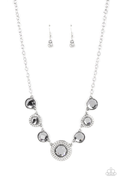 Extravagant Extravaganza Silver Necklace - Paparazzi Accessories  Oversized smoky gems alternate with matching gems bordered in rings of glassy white rhinestones below the collar, resulting in a spellbinding sparkle at the bottom of a classic silver chain. Features an adjustable clasp closure.  Sold as one individual necklace. Includes one pair of matching earrings.