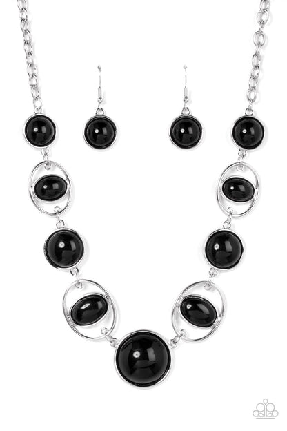Eye of the BEAD-holder Black Necklace - Paparazzi Accessories  Encased in sleek silver frames, a bubbly collection of oversized black beads alternate with oval black beaded hoops below the collar for a bodacious pop of color. Features an adjustable clasp closure.  Sold as one individual necklace. Includes one pair of matching earrings.