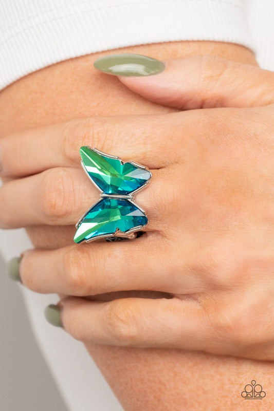 Fluorescent Flutter Green Butterfly Ring - Paparazzi Accessories  Featuring a stellar blue UV finish, a pair of glittery green gems adorns the wings of a silver butterfly atop the finger for an eye-catching finish. Features a stretchy band for a flexible fit.  Sold as one individual ring.