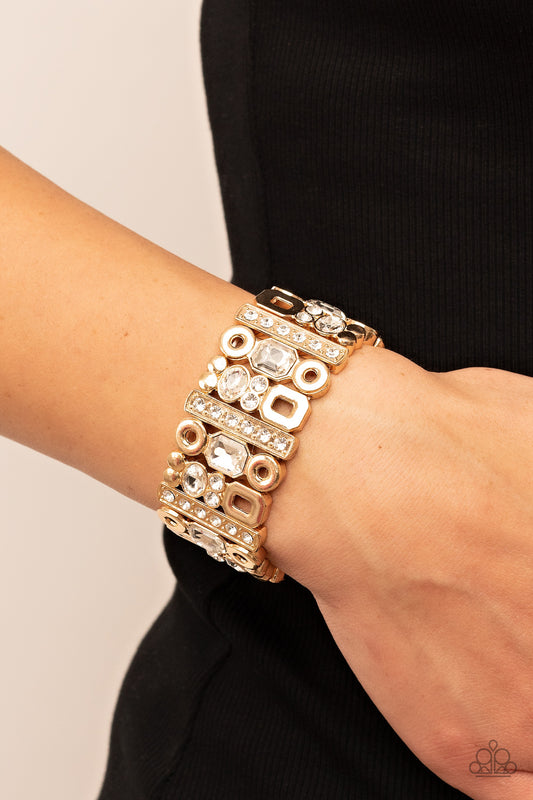 Dynamically Diverse Gold Bracelet - Paparazzi Accessories  Infused with flat gold studs and geometric gold accents, a mismatched assortment of oval, round, and emerald style white rhinestones coalesce into edgy frames along a stretchy band for an intense sparkle around the wrist.  Sold as one individual bracelet.