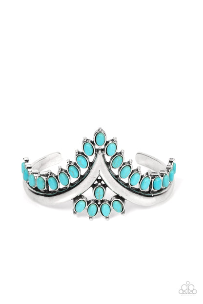 Teton Tiara Blue Cuff Bracelet - Paparazzi Accessories  Turquoise oval stones, encased in studded silver frames, line the edge of a daring V-shaped silver cuff. A gathering of turquoise stones adorns the center of the bracelet, adding a finishing touch to the rustically regal cuff.  Sold as one individual bracelet.