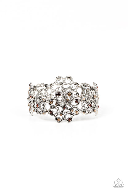 Regal Recognition Brown Bracelet - Paparazzi Accessories  Dainty topaz and golden topaz rhinestones scatter across the fronts of airy medallions fashioned from whimsical heart-shaped filigree. The splendid frames alternate along stretchy bands resulting in a regally refined design that wraps around the wrist.  Sold as one individual bracelet.