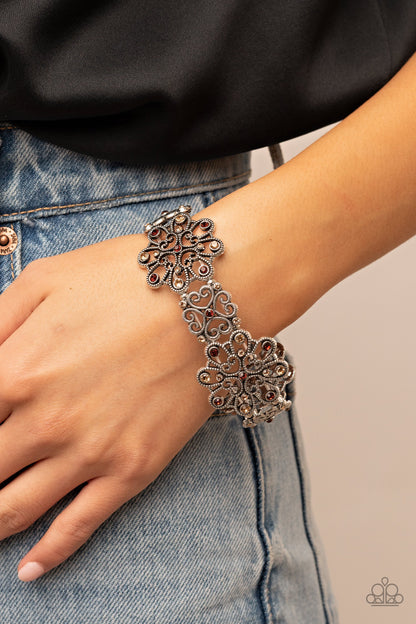 Regal Recognition Brown Bracelet - Paparazzi Accessories  Dainty topaz and golden topaz rhinestones scatter across the fronts of airy medallions fashioned from whimsical heart-shaped filigree. The splendid frames alternate along stretchy bands resulting in a regally refined design that wraps around the wrist.  Sold as one individual bracelet.