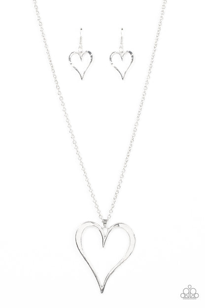 Hopelessly In Love Silver Necklace - Paparazzi Accessories  Featuring subtle hammered details, an oversized silver heart pendant swings from the bottom of a classic silver chain for a rustically romantic shimmer. Features an adjustable clasp closure.  Sold as one individual necklace. Includes one pair of matching earrings.