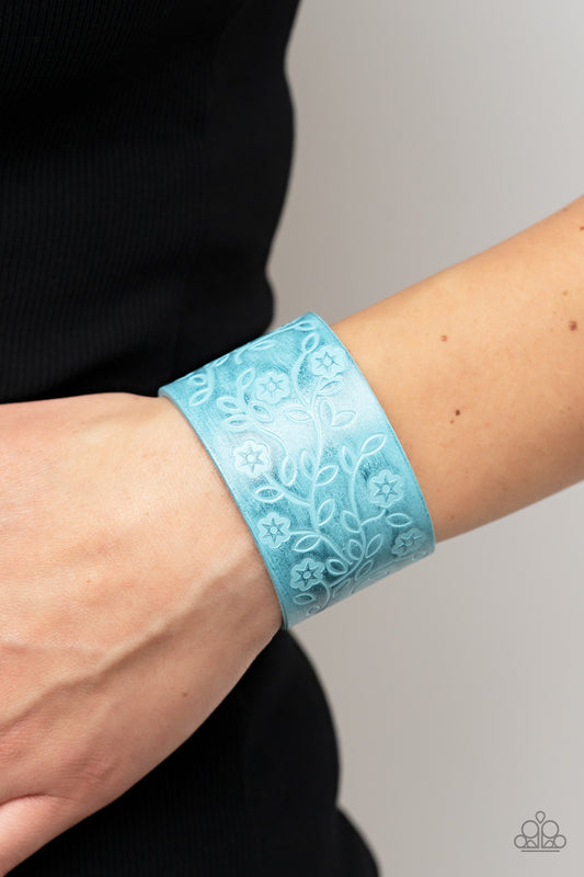 Rosy Wrap Up Blue Bracelet - Paparazzi Accessories  A flowery and leafy motif blooms across the front of a distressed blue leather band, resulting in a rustic floral centerpiece around the wrist. Features an adjustable snap closure.  Sold as one individual bracelet.