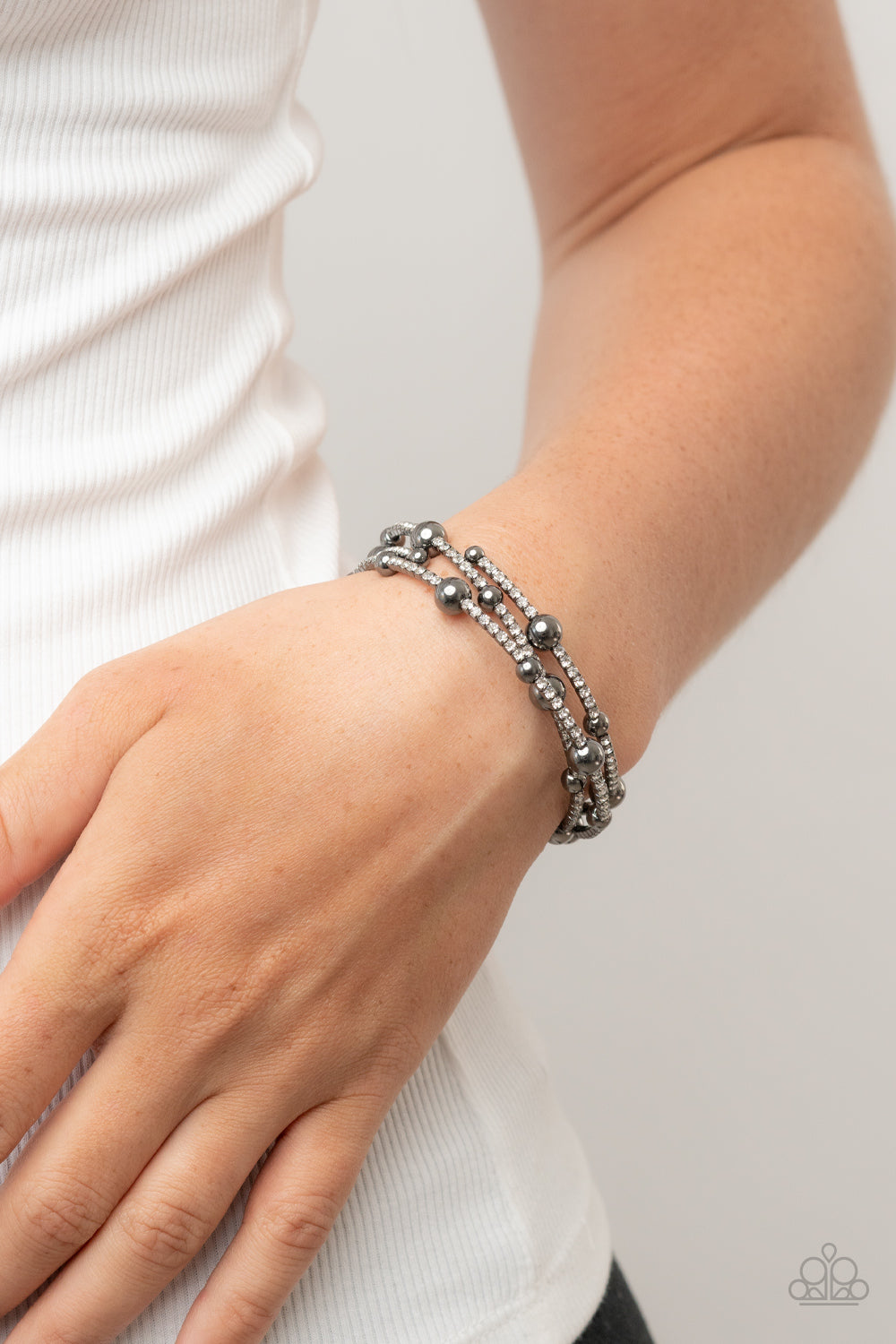 Spontaneous Shimmer Black Bracelet - Paparazzi Accessories  Spontaneously interrupted by glistening gunmetal beads, a sparkly strand of white rhinestones coils around the wrist, resulting in an irresistible infinity wrap bracelet.  Sold as one individual bracelet.