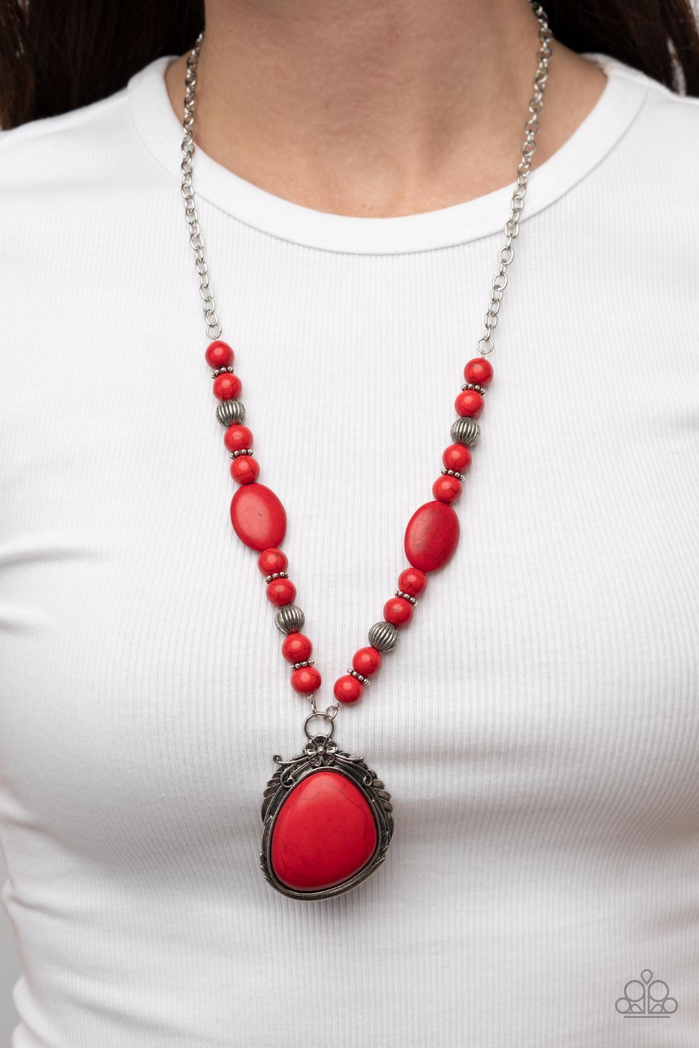 Southwest Paradise Red Necklace - Paparazzi Accessories  A lengthened silver chain flows into a succession of polished red stone beads and silver accents. The flowy display gives way to an opulent red stone that is pressed into an ornate silver frame. Adorned with fanciful antiqued silver flower, vine, and feather-like motifs, the elegantly rustic pendant makes a striking impact. Features an adjustable clasp closure.  Sold as one individual necklace. Includes one pair of matching earrings.