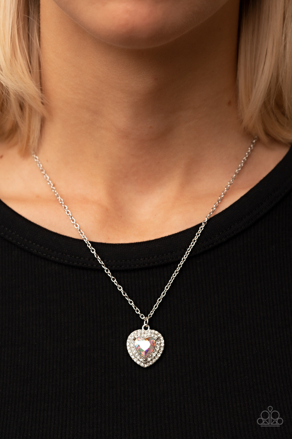 Taken with Twinkle Multi Necklace - Paparazzi Accessories  Bordered in stacked rows of glassy white rhinestones, a twinkly iridescent heart shaped gem sparkles at the center of a dainty silver chain for a flirtatious fashion. Features an adjustable clasp closure.  Sold as one individual necklace. Includes one pair of matching earrings.