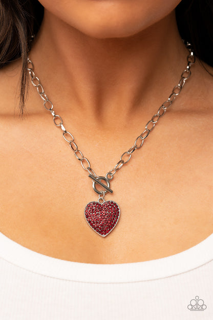 If You LUST Red Heart Necklace - Paparazzi Accessories  A fiery red rhinestone dotted silver heart frame sparkles from a toggle closure at the center of an oval silver linked chain for a flirtatious fashion. Features a toggle closure.  Sold as one individual necklace. Includes one pair of matching earrings.