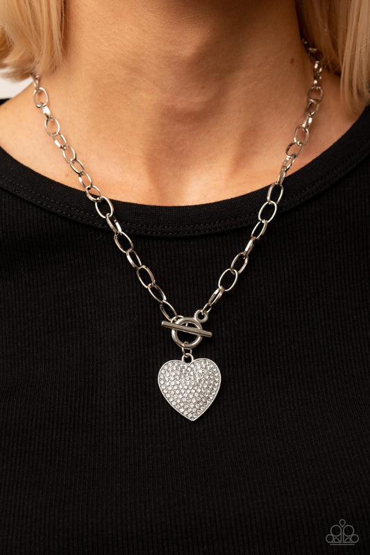 If You LUST White Necklace - Paparazzi Accessories  A white rhinestone dotted silver heart frame sparkles from a toggle closure at the center of an oval silver linked chain for a flirtatious fashion. Features a toggle closure.  Sold as one individual necklace. Includes one pair of matching earrings.
