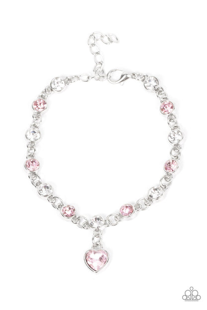 True Love Trinket Pink Necklace & Bracelet Set - Paparazzi Accessories A pink rhinestone heart charm dances from a strand of white and pink rhinestones, resulting in a flirtatious sparkle below the collar and around the wrist. Sold as one individual necklace. Includes one matching bracelet. Get The Complete Look! Bracelet: "Truly Lovely - Pink"