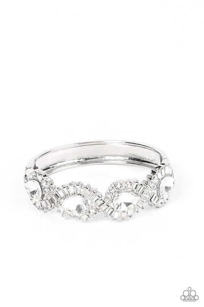 For the Win White Bracelet - Paparazzi Accessories  Ribbons of emerald and round cut rhinestones loop around dramatically oversized teardrop rhinestones, resulting in an explosion of sparkle across the front of a jaw-dropping bangle-like bracelet. Features a hinged closure.  Sold as one individual bracelet.