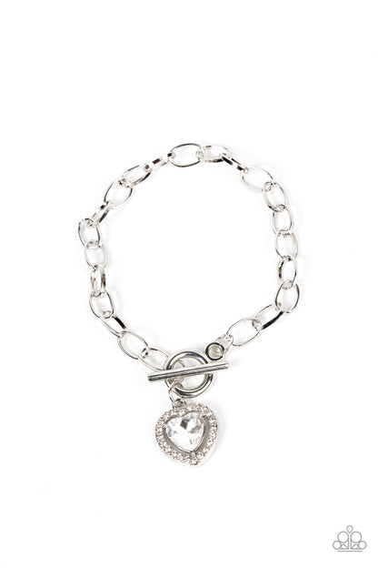 Till DAZZLE Do Us Part White Bracelet - Paparazzi Accessories  Bordered in glassy white rhinestones, a white heart shaped gem sparkles from a toggle closure at the center of an oval silver linked chain for a flirtatious fashion around the wrist. Features a toggle closure.  Sold as one individual bracelet.