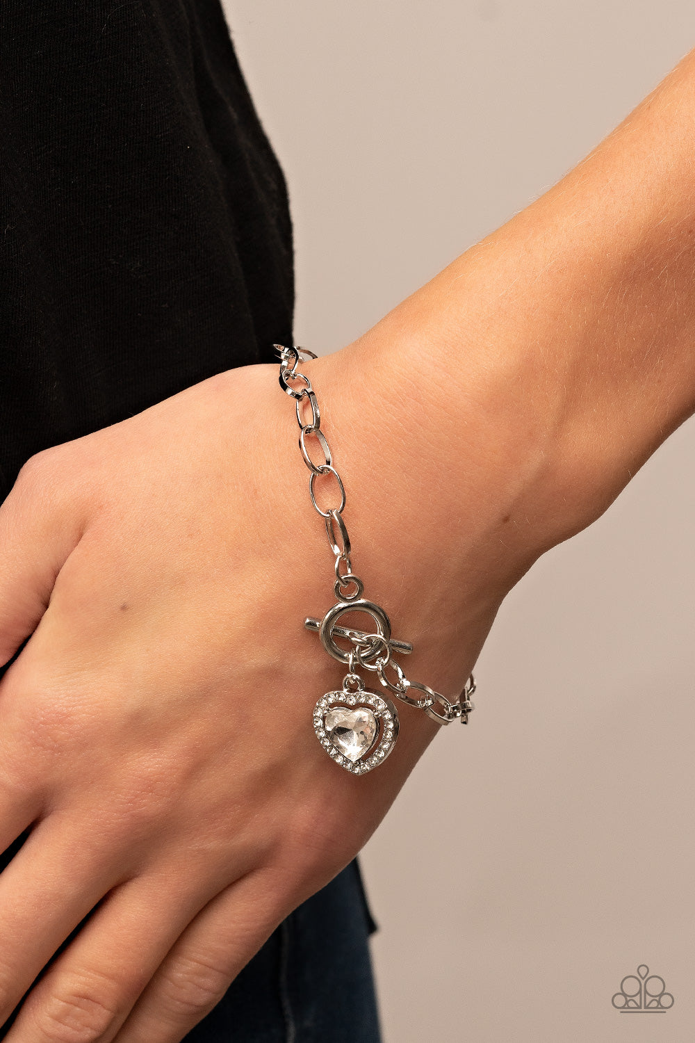 Till DAZZLE Do Us Part White Bracelet - Paparazzi Accessories  Bordered in glassy white rhinestones, a white heart shaped gem sparkles from a toggle closure at the center of an oval silver linked chain for a flirtatious fashion around the wrist. Features a toggle closure.  Sold as one individual bracelet.