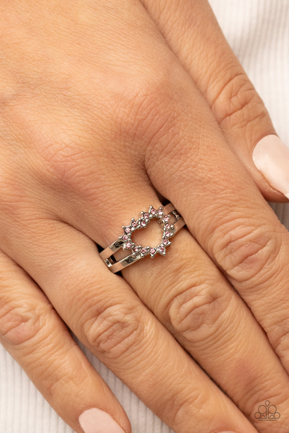 First Kisses Pink Heart Ring - Paparazzi Accessories  Pink rhinestone pronged silver fittings coalesce into an airy heart frame atop the center of layered silver frames, resulting in a romantic centerpiece atop the finger. Features a dainty stretchy band for a flexible fit.  Sold as one individual ring.