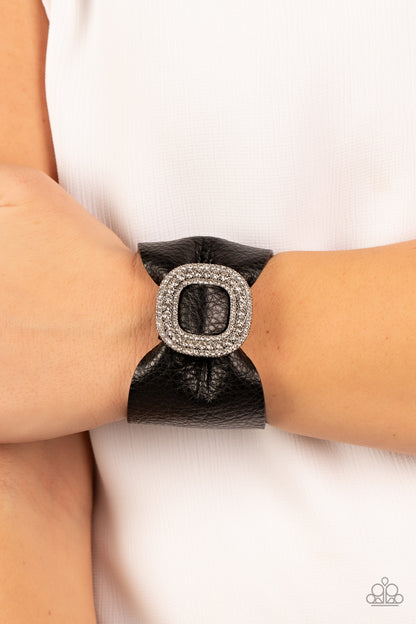 Lights, SELFIE, Action! Black Wrap Bracelet - Paparazzi Accessories  A thick black pleather band delicately knots around the wrist. Stacked with brilliant white rhinestones, a dramatic silver buckle sparkles at the center of the wrist for a dramatic finish. Features an adjustable snap closure.  Sold as one individual bracelet.
