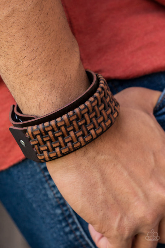 Urban Expansion Brown Wrap Bracelet - Paparazzi Accessories   Distressed leather laces weave into a wicker-like pattern, creating a thick band of texture that wraps around a leather band. The textured overlay is studded in place across the front of the brown leather band, resulting in a rustic centerpiece. Features an adjustable snap closure.  Sold as one individual bracelet.
