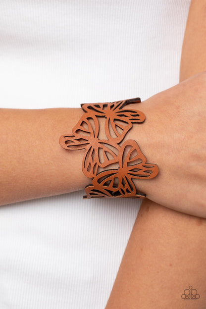 Butterfly Breeze Brown Bracelet - Paparazzi Accessories  Featuring an airy stenciled pattern, brown leather butterflies flutter across the wrist as they delicately connect into a rustic centerpiece. Features an adjustable snap closure.  Sold as one individual bracelet.