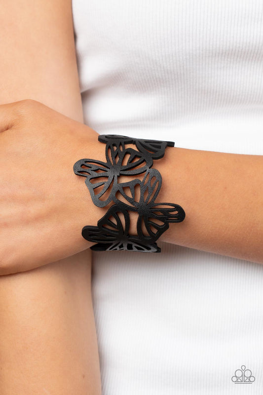Butterfly Breeze Black Wrap Bracelet - Paparazzi Accessories  Featuring an airy stenciled pattern, black leather butterflies flutter across the wrist as they delicately connect into a rustic centerpiece. Features an adjustable snap closure.  Sold as one individual bracelet.