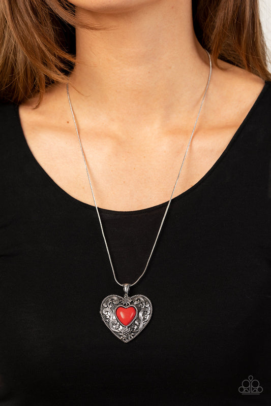 Wholeheartedly Whimsical Red Necklace - Paparazzi Accessories  Embossed in whimsical flowers and vines, a rustic silver heart frame is adorned with a red stone heart center for an adoring artisan finish as it glides along a rounded silver snake chain across the chest. Features an adjustable clasp closure.  Sold as one individual necklace. Includes one pair of matching earrings.