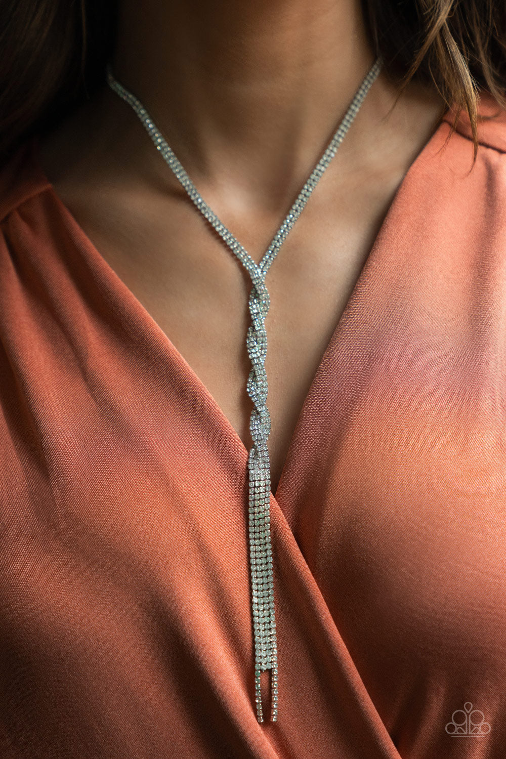 Impressively Icy White Necklace - Paparazzi Accessories  Silvery ribbons of glassy white rhinestones loop around the neck and delicately twist into an icy tassel down the chest. Features an adjustable clasp closure.  Sold as one individual necklace. Includes one pair of matching earrings.