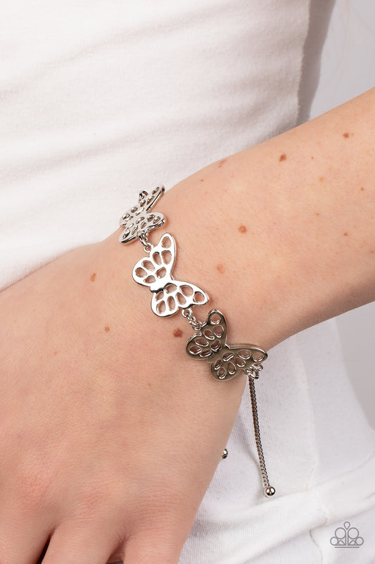 Put a WING on It Silver Bracelet - Paparazzi Accessories  Featuring airy stenciled cutouts, three silver butterflies delicately connect at the center of a silver box chain for a whimsical fashion. Features an adjustable sliding bead closure.  Sold as one individual bracelet.