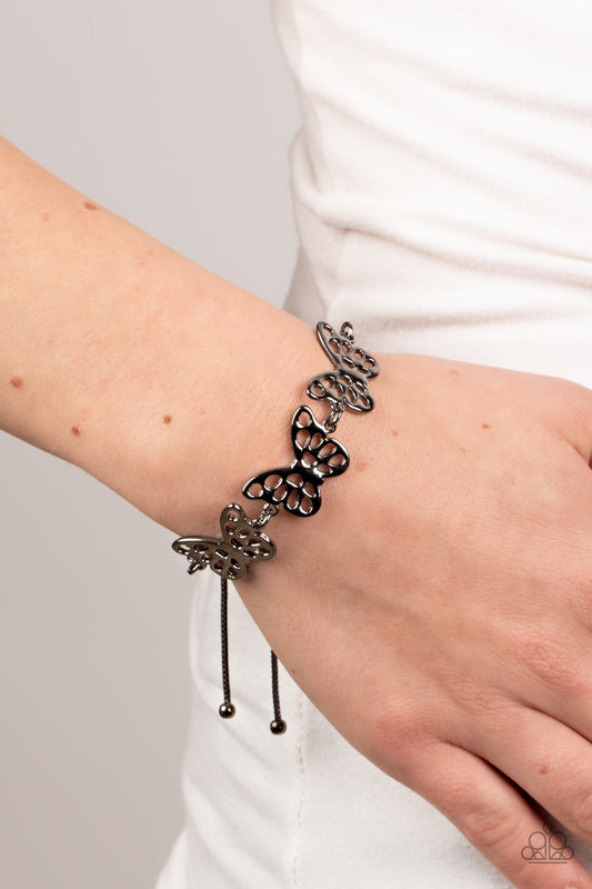 Put a WING on It Black Bracelet - Paparazzi Accessories  Featuring airy stenciled cutouts, three gunmetal butterflies delicately connect at the center of a gunmetal box chain for a whimsical fashion. Features an adjustable sliding bead closure.  Sold as one individual bracelet.