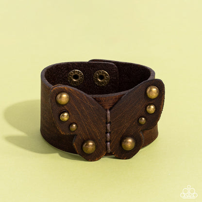 Butterfly Farm Brass Wrap Bracelet - Paparazzi Accessories  Dotted with antiqued brass studs, a distressed leather butterfly is studded in place across the center of a distressed brown leather band for a rustic flair. Features an adjustable snap closure.  Sold as one individual bracelet.  P9UR-BRXX-058XX