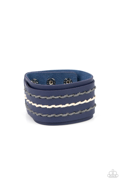 Real Ranchero Blue Wrap Bracelet - Paparazzi Accessories Item #P9UR-BLXX-229XX Three rows of gray and white cording are laced down the center of a blue leather band that is studded in place across the front of a thick blue leather band, resulting in a rustic pop of color around the wrist. Features an adjustable snap closure.  Sold as one individual bracelet.