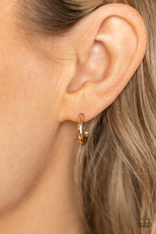 Small-Scale Shimmer Gold Hoop Earring - Paparazzi Accessories  A bold gold bar gently curves into a dainty hoop, creating a classic shimmer. Earring attaches to a standard post fitting. Hoop measures approximately 1/2" in diameter.  Sold as one pair of hoop earrings.