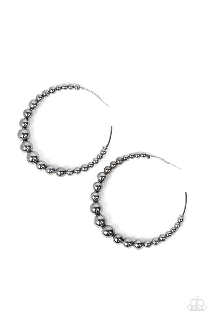 Show Off Your Curves Gunmetal Hoop Earring - Paparazzi Accessories  Gradually increasing in size, glistening gunmetal beads are threaded along an oversized gunmetal hoop for a gritty and glamorous effect. Earring attaches to a standard post fitting. Hoop measures approximately 2 1/2" in diameter.  Sold as one pair of hoop earrings.