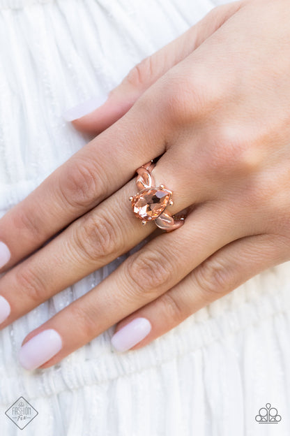 Law of Attraction Rose Gold Ring - Paparazzi Accessories  A luxurious peach teardrop gem sits regally atop a twisted rose gold band, creating a stunning centerpiece atop the finger. Features a dainty stretchy band for a flexible fit.  Sold as one individual ring.