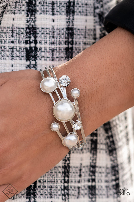 Total SAIL-Out White Cuff Bracelet - Paparazzi Accessories  Luxuriously oversized pearl beads, encased in silver frames, mingle with brilliant white rhinestones, as they drift across silver bands that flare out on either side before wrapping into an airy cuff around the wrist.  Sold as one individual bracelet.