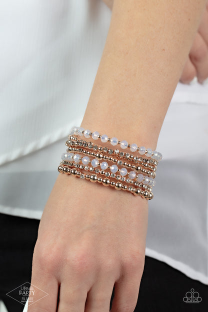 ICE Knowing You Rose Gold Bracelet - Paparazzi Accessories  An icy collection of rose gold beads, rose gold cubes, opaque crystals, and glassy white rhinestones are threaded along a coiled wire, creating a blinding infinity wrap style bracelet around the wrist.  Sold as one individual bracelet. This Fan Favorite is back in the spotlight at the request of our 2021 Life of the Party member with Pink Diamond Access, Crystal R.