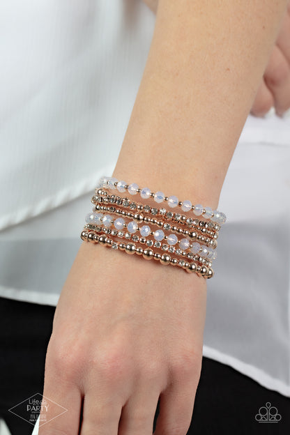 ICE Knowing You Rose Gold Bracelet - Paparazzi Accessories  An icy collection of rose gold beads, rose gold cubes, opaque crystals, and glassy white rhinestones are threaded along a coiled wire, creating a blinding infinity wrap style bracelet around the wrist.  Sold as one individual bracelet. This Fan Favorite is back in the spotlight at the request of our 2021 Life of the Party member with Pink Diamond Access, Crystal R.